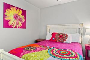 Un dormitorio con una cama con almohadas de colores. en 5 O'Clock Somewhere - Hot Tub Pool Fire Pit, en Fredericksburg 72 fotos más