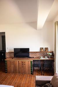 a living room with a flat screen tv on a wooden cabinet at Studio São Lucas super localizado frente praia in São Vicente