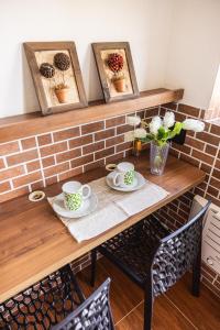 a table with two plates and two cups on it at Studio São Lucas super localizado frente praia in São Vicente