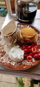 a plate of food with pancakes and a cup of coffee at Koppány Pines - Bell Tent B & B Rooms in Koppányszántó