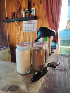 a table with glasses and jars on a wooden table at Baguales Patagonia in Puerto Cisnes +8 photos
