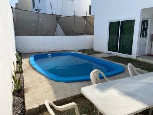 a blue swimming pool sitting next to a table at Casa LUNA in Tuxpan de Rodríguez Cano