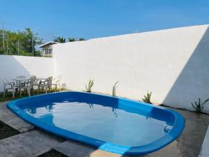 a blue swimming pool in front of a white wall at Casa LUNA in Tuxpan de Rodríguez Cano