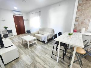 ein Wohnzimmer mit einem Tisch und einem Stuhl in der Unterkunft Huelin playa in Málaga