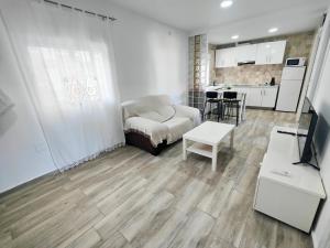 ein Wohnzimmer mit Couch und Küche in der Unterkunft Huelin playa in Málaga