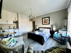 a bedroom with a bed and a dining room at Hermanus Sea view room in Hermanus