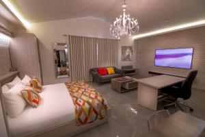 フリータウンにあるHome Suites Boutique Hotel Freetownの大きなベッドとリビングルームのある寝室