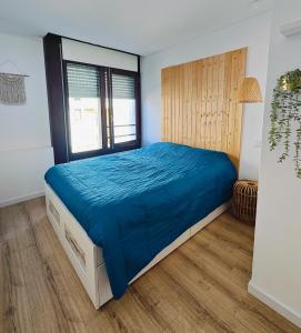 a bedroom with a large bed with blue sheets at Casa do Sal in Troia