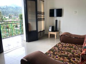 a living room with a couch and a balcony at Small Land Home Stay in Kibuye