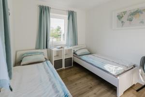 une chambre avec deux lits et une fenêtre dans l'établissement Ferienhaus Wiesenkiek - Bauernhof Hopp Vadersdorf, à Fehmarn