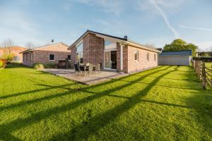 une grande cour avec une maison en briques dans l'établissement Ferienhaus Wiesenkiek - Bauernhof Hopp Vadersdorf, à Fehmarn
