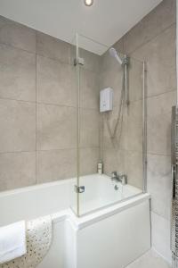 a bathroom with a shower with a tub and a sink at StayByNumbers - City Centre Victorian Townhouse in Belfast +42 photos