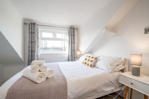 a bedroom with a white bed with towels on it at StayByNumbers - City Centre Victorian Townhouse in Belfast