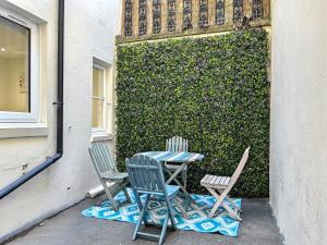 two chairs and a table in front of a wall at The Beach Garden Flat in Brighton & Hove