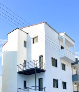 a white building with a balcony on it at Spacious, Near Beach & Easy Parking - by Solstad in Kavala