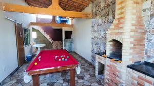 a red table in a room with a brick fireplace at 2 Quartos, 2 Banheiros churrasqueira 600m da Praia in Rio das Ostras