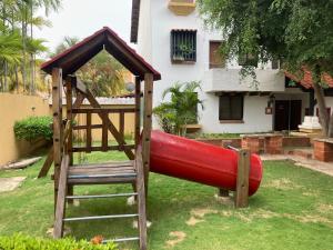a playground with a red slide in front of a house at Lecheria exclusivo con muelle in El Morto de Barcelona