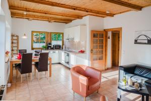 une cuisine et une salle à manger avec une table et des chaises dans l'établissement Ferienwohnung Fachwerkhaus - Westen unten - Bauernhof Hopp Vadersdorf, à Fehmarn