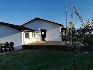 a white house with a deck and a table at Cozy house in Hjoerring close to city & nature in Hjørring
