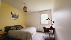 1 dormitorio con 1 cama y escritorio con lámpara en Le Gabrielle-Charmant Appartement-Parking, en Rouen