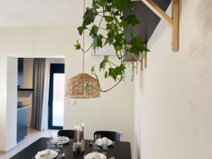 a dining room with a table and a potted plant at Spacious, Near Beach & Easy Parking - by Solstad in Kavala