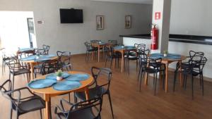 a room full of tables and chairs with blue seats at Hotel Iaguara in Coxim