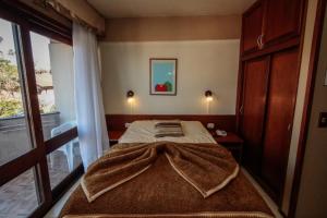 a bedroom with a bed with a blanket on it at pousada do serrano in Gramado +9 photos