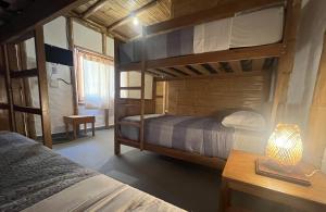 a bedroom with two bunk beds and a table with a lamp at Cabo del Mar in Los Órganos