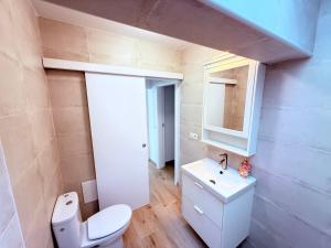 Un baño con un inodoro blanco y un lavabo. en La casa de la playa, en Playa Quemada 32 fotos más