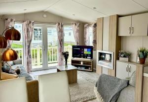 a living room with a couch and a tv at Isle Escape in Rookley