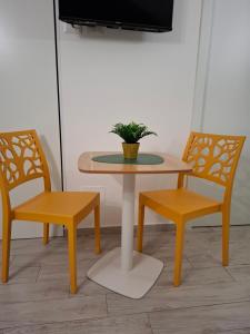 un tavolo e due sedie con una pianta in vaso di Borghetto Capuana House a Catania