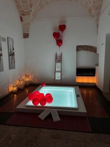 a pool in a room with red balloons and a fireplace at Suite87 in Mesagne