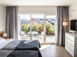 une chambre d'hôtel avec un lit et une grande fenêtre dans l'établissement Apartamenty Czarna Góra Resort - Livigno 1 i 2, à Sienna