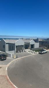 a parking lot with cars parked in front of a building at Calypso beach holiday in Langebaan