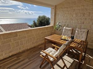 a table and chairs on a balcony with a view of the ocean at Blue Horizon Rezevici in Katun