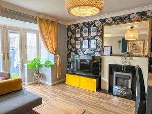 a living room with a television and a mirror at Mayflower 3 Bedrooms House 7 Beds 2 Showers Off Road Parking in Barnsley