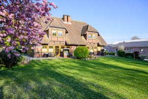 une grande maison avec une grande cour avec de l'herbe verte dans l'établissement Ferienwohnung Fachwerkhaus - Süden unten - Bauernhof Hopp Vadersdorf, à Fehmarn