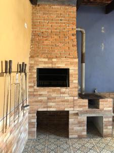 Una chimenea de ladrillo en una habitación con ladrillo en Recanto com piscina, churrasqueira e 3 quartosl!, en Pelotas