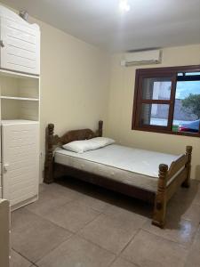 un dormitorio con una cama y una ventana en Recanto com piscina, churrasqueira e 3 quartosl!, en Pelotas 21 fotos más