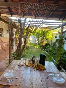 a wooden table with a bunch of bananas on it at Pousada Vento Norte in São Miguel do Gostoso