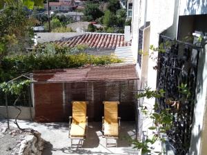 two chairs and a dog house in the courtyard of a building at Chambre Proche Plage du Prophète in Marseille