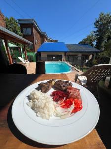 a plate of food with rice and meat on a table at Hotel Los Lapachos in Puerto Iguazú