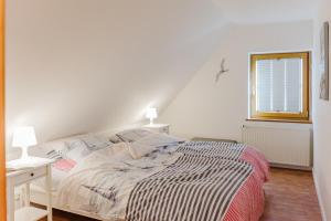 une chambre blanche avec un lit et une fenêtre dans l'établissement Ferienwohnung Fachwerkhaus - Süden oben - Bauernhof Hopp Vadersdorf, à Fehmarn