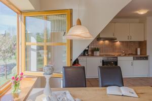 une cuisine et une salle à manger avec une table et des chaises dans l'établissement Ferienwohnung Fachwerkhaus - Süden oben - Bauernhof Hopp Vadersdorf, à Fehmarn