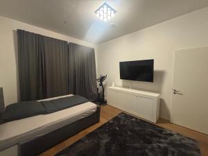 a bedroom with a bed and a flat screen tv at 2 Rooms Shanghaiallee Appartment in Hamburg