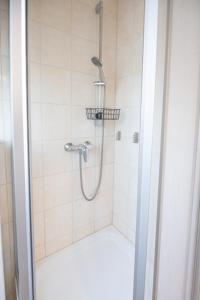 une douche avec pommeau de douche dans une salle de bain dans l'établissement Landhaus Ferienwohnung 1 - Bauernhof Hopp Vadersdorf, à Fehmarn 25 autres photos