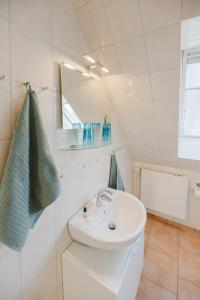 une salle de bains avec un lavabo blanc et un miroir dans l'établissement Landhaus Ferienwohnung 1 - Bauernhof Hopp Vadersdorf, à Fehmarn