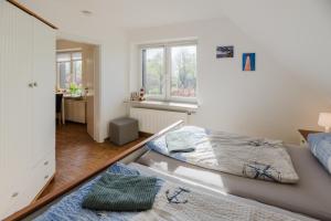 - une chambre avec 2 lits et un bureau dans l'établissement Landhaus Ferienwohnung 1 - Bauernhof Hopp Vadersdorf, à Fehmarn