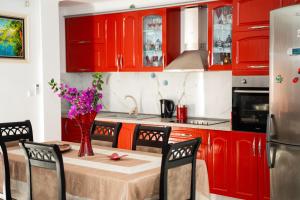 a kitchen with red cabinets and a table with flowers on it at Villa Sonil & Xhulio in Ksamil