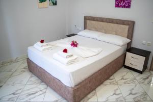 a bedroom with a bed with towels and flowers on it at Villa Sonil & Xhulio in Ksamil